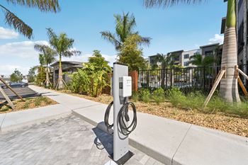 A charging station for electric vehicles is located on a sidewalk at The Concord Luxury Apartments, Sarasota, FL